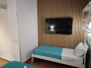 une chambre avec un lit et une télévision sur un mur dans l'établissement BnBsimy5, à Naples