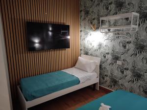 une petite chambre avec un lit avec une télévision au mur dans l'établissement BnBsimy5, à Naples