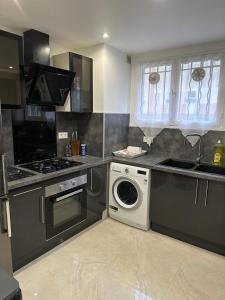 een keuken met een wasmachine en een wasmachine bij Appartement Amaya 1 - 100 m2 Paris 2024 in Pontoise