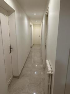 een hal met witte muren en een lange hal met een bank bij Appartement Amaya 1 - 100 m2 Paris 2024 in Pontoise +21 foto's