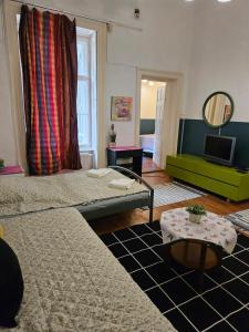 ブダペストにあるDanube Bridge Apartmentsのリビングルーム(ベッド2台、緑のソファ付)