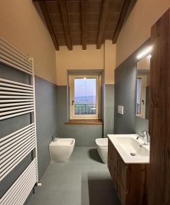 La salle de bains est pourvue de 2 lavabos, de toilettes et d'une fenêtre. dans l'établissement La Valle del Re - Agriturismo, à Medesano