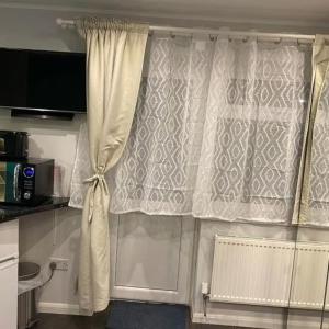 uma janela com uma cortina numa cozinha em Vika Residence Deluxe Apartments Wednesbury Holiday Resort em Wednesbury