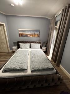 a bedroom with a large bed with two windows at Haus in Harburger Berge in Hamburg