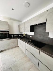 a kitchen with white cabinets and black counter tops at Haus in Harburger Berge in Hamburg