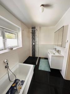 a white bathroom with a tub and a sink at Haus in Harburger Berge in Hamburg