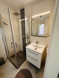 a white bathroom with a sink and a shower at Haus in Harburger Berge in Hamburg