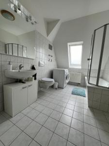 a white bathroom with a sink and a toilet at 1 Raum Wohnung in ruhiger Lage in Limbach-Oberfrohna