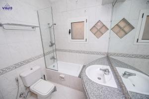 a white bathroom with a sink and a toilet at Villa 13 Luxury suites in Cairo