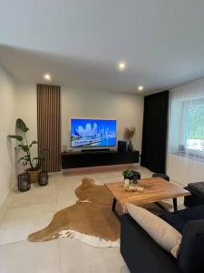 a living room with a table and a tv at AURA Hlinsko in Hlinsko