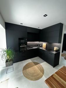 a kitchen with black walls and a table and a rug at AURA Hlinsko in Hlinsko
