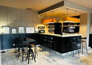 une cuisine avec un comptoir noir et des tabourets de bar dans l'établissement Hotel Ignacio - PalomarGroup, à Chiva