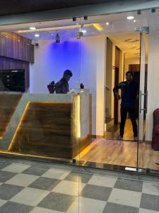 two men standing behind a counter in a room at Airport Hotel Relax Inn in Nagpur