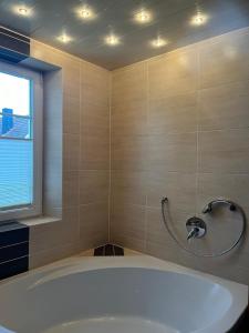 een badkamer met een bad en een raam bij Ferienwohnung Tina in Burgkunstadt