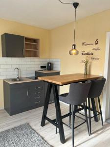 Una cocina con una mesa de madera y dos sillas. en Ferienwohnung Tina, en Burgkunstadt