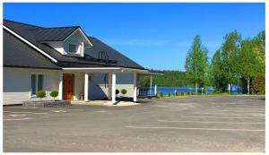 un edificio con aparcamiento junto a un lago en AaltoSahan huvila, en Orivesi