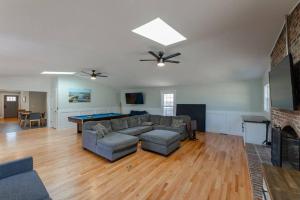 a living room with a couch and a pool table at Spacious Midtown Ranch- 10 min to Wrightsville in Wilmington