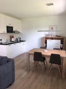 a living room with a table and chairs and a kitchen at Your little home in Hamburg Osdorf in Hamburg