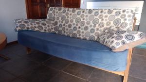 a blue couch with a blanket on top of it at Casa dique Pet Friendly in Tandil