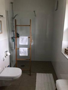 a bathroom with a toilet and a shower with towels at Your little home in Hamburg Osdorf in Hamburg