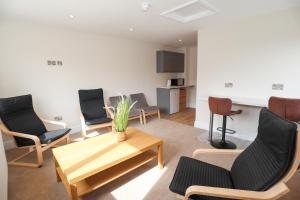 a living room with chairs and a coffee table at Green Nest Room with private bathroom in Eastbourne