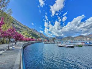 une rivière avec des bateaux amarrés à côté d'une montagne dans l'établissement INES HOME tra lago e montagna - Lago d'Iseo, à Pisogne