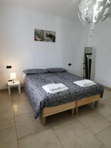 1 dormitorio con 1 cama con 2 toallas en INES HOME tra lago e montagna - Lago d'Iseo en Pisogne