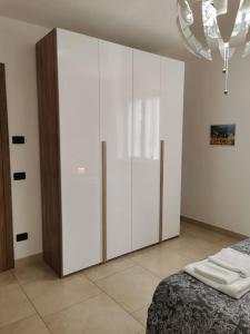 1 dormitorio con armario blanco grande y cama en INES HOME tra lago e montagna - Lago d'Iseo en Pisogne