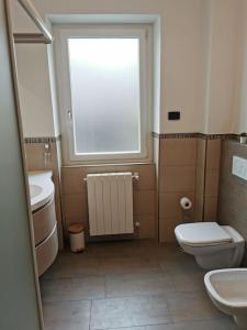 La salle de bains est pourvue de toilettes, d'un lavabo et d'une fenêtre. dans l'établissement INES HOME tra lago e montagna - Lago d'Iseo, à Pisogne