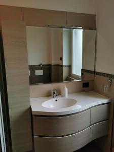 La salle de bains est pourvue d'un lavabo et d'un miroir. dans l'établissement INES HOME tra lago e montagna - Lago d'Iseo, à Pisogne