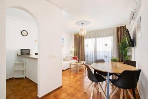 サンミゲル・デ・アボナにあるTu hogar en Tenerife ,Parque Albatrosのテーブルと椅子、リビングルームが備わる客室です。