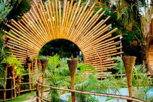 un grande arco in legno in un giardino con piante di The Lazy Cabanas a Candolim
