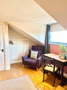 uma sala de estar com uma cadeira roxa e uma mesa em Inviting townhouse in Bedlington em Bedlington