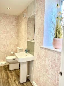 a bathroom with a sink and a toilet and a mirror at Inviting townhouse in Bedlington in Bedlington