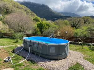 a hot tub in a field with a mountain at Guest House Mare in Bar