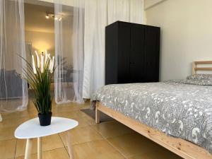 a bedroom with a bed and a table with a potted plant at STUDIO in Limassol