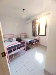 a room with two beds and a window at Las Palmeras del Cantal in Mojácar