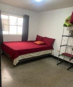 Un dormitorio con una cama con sábanas rojas y una escalera en Guest House Casa Las Lajas, en Antigua Guatemala