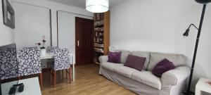 ein Wohnzimmer mit einer weißen Couch und lila Kissen in der Unterkunft Apartamento Santander zona Tetuán Puertochico in Santander