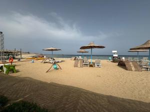plaża z parasolami i krzesłami oraz ocean w obiekcie Marvel loli camp w mieście Al-Kusajr