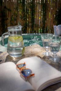 a book and glasses on a table next to a swimming pool at Villa Mediterrâneo Trancoso in Trancoso