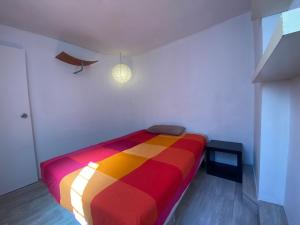 sypialnia z kolorowym łóżkiem w pokoju w obiekcie Cozy apartment in the city centre of Barcelona w Barcelonie