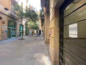 pusta ulica w alejce pomiędzy dwoma budynkami w obiekcie Cozy apartment in the city centre of Barcelona w Barcelonie