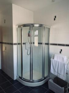 a glass shower in a bathroom with a towel at St John's B and B in Roscommon