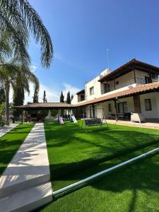 a large yard with a building and a grass field at Leo's Paradise in Protaras