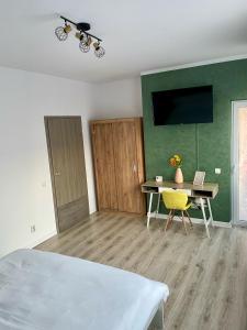 een kamer met een bed, een bureau en een televisie bij Greenlight Studio by DAT Apartments in Cluj-Napoca