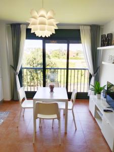 a dining room with a white table and chairs at Piso ESPAZ in Isla de Arosa