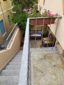 una escalera que conduce a un edificio con flores en Appartamento a 50 mt dal mare, en Cala Gonone