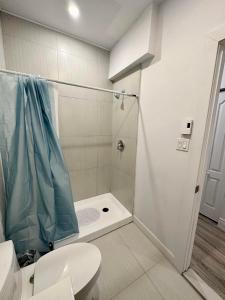 a bathroom with a shower with a toilet and a sink at Appartement 1 chambre - 101 in Montréal
