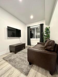 sala de estar con sofá y TV de pantalla plana en Appartement 1 chambre - 101, en Montreal